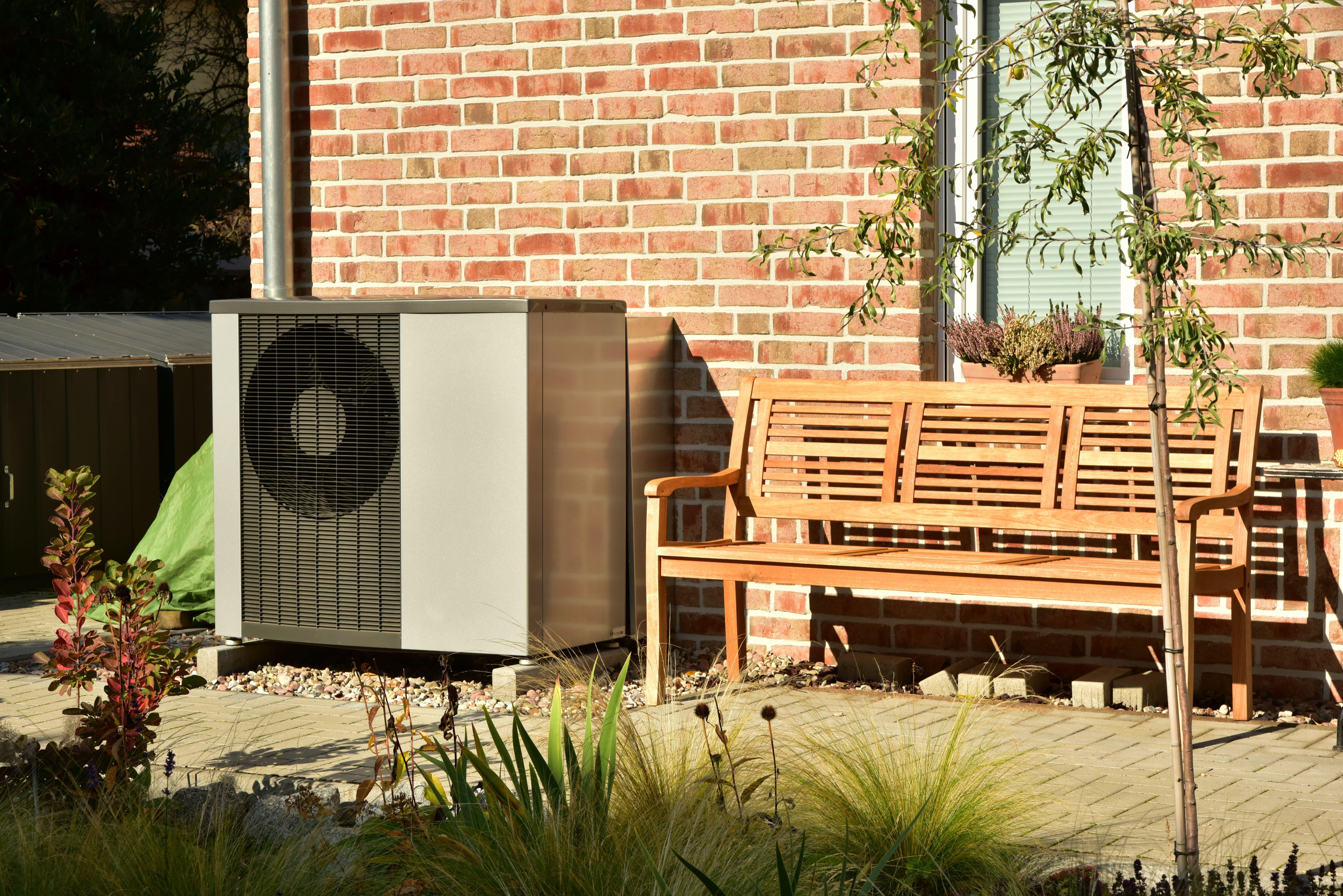 Wärmepumpe im Garten neben einer Terrasse