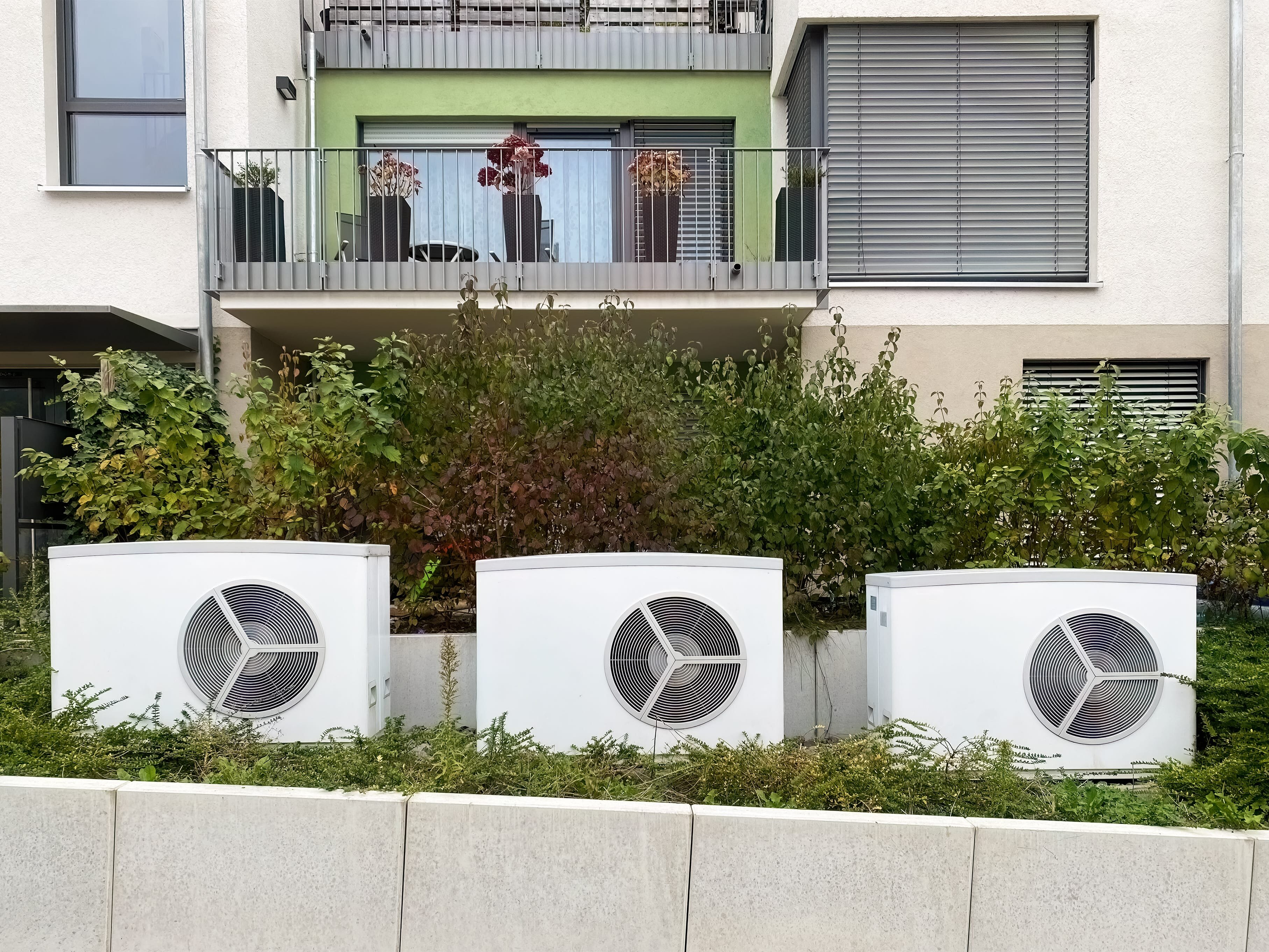 Wärmepumpen vor einem Mehrfamilienhaus